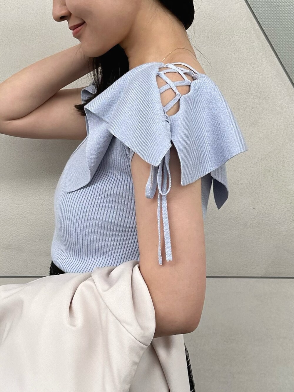 その他のサンダル、ブラック系のハンドバッグ、ブルー系のニット/セーターを着用したレディースの春コーディネートの5枚目の写真