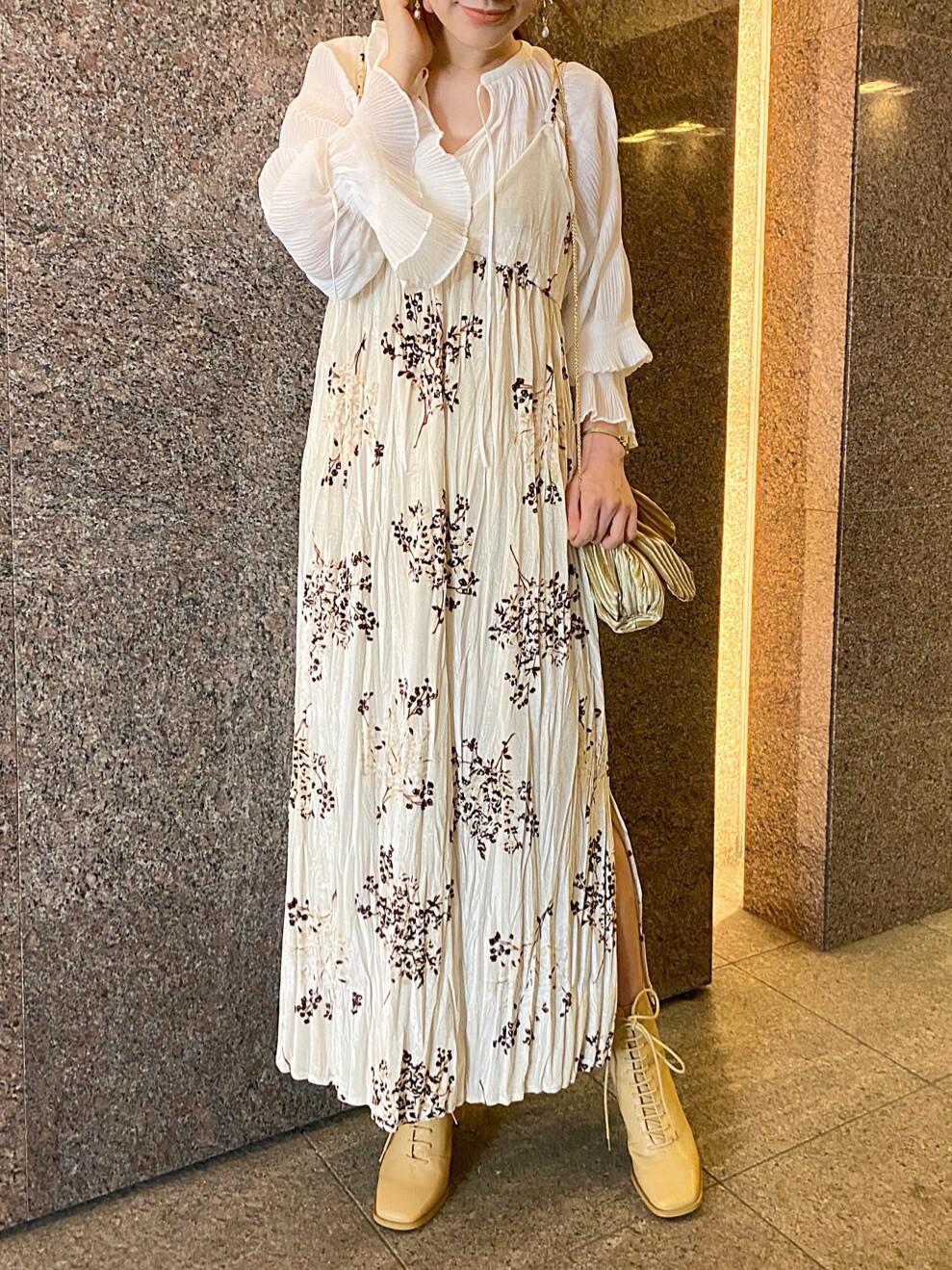 ベージュ系のワンピース、ホワイト系のシャツ/ブラウス、ベージュ系のクラッチバッグを着用したレディースの秋コーディネートの3枚目の写真