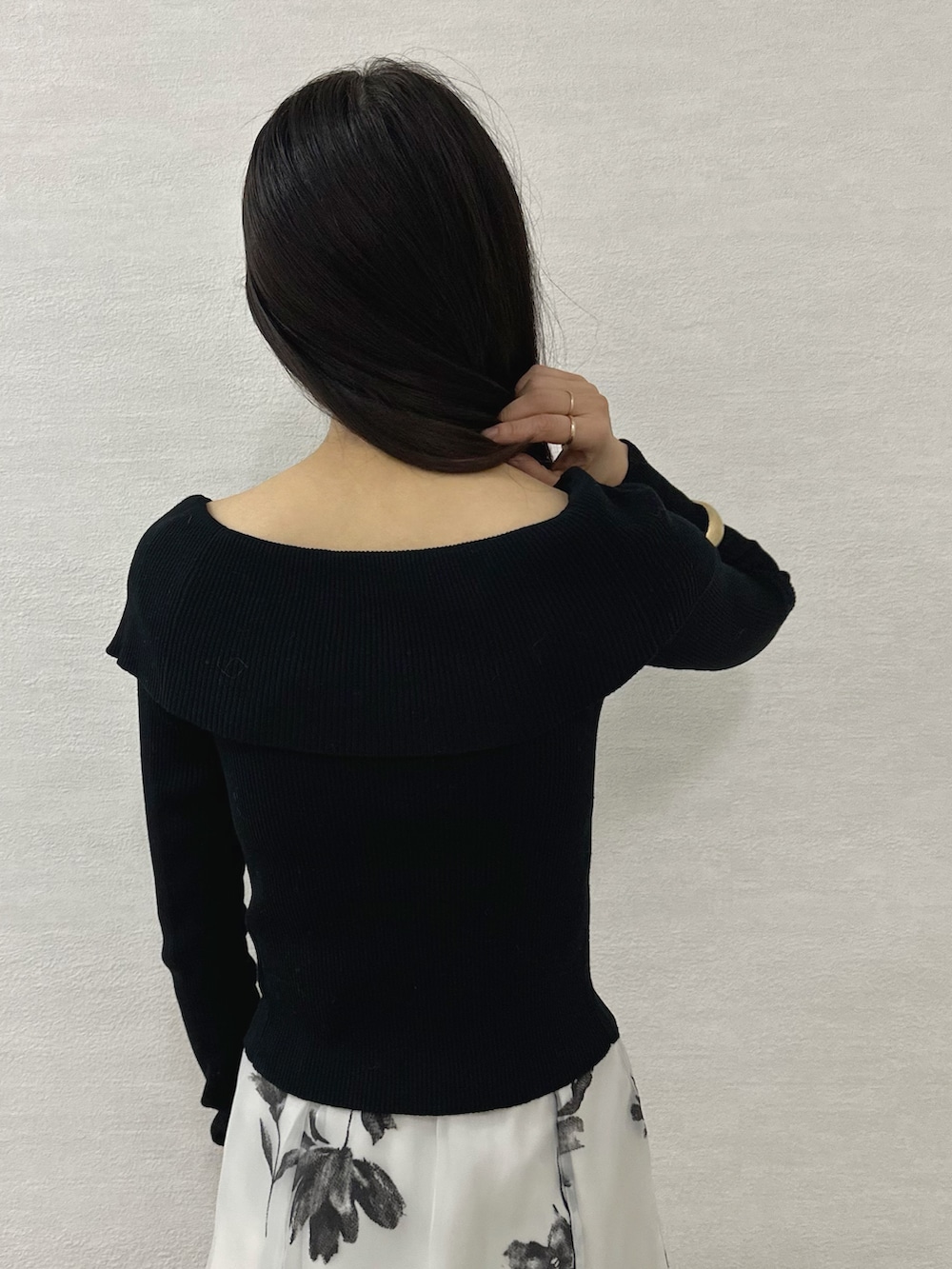 ブラック系のニット/セーター、ブラック系のブーツ、レッド系のハンドバッグを着用したレディースの秋コーディネートの7枚目の写真