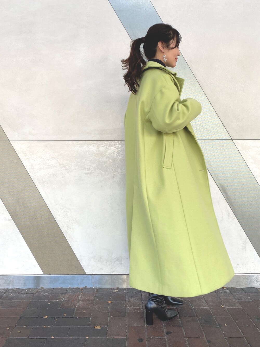 ブラック系のブーツ、グリーン系のステンカラーコート、グリーン系のステンカラーコートを着用したレディースの秋コーディネートの3枚目の写真