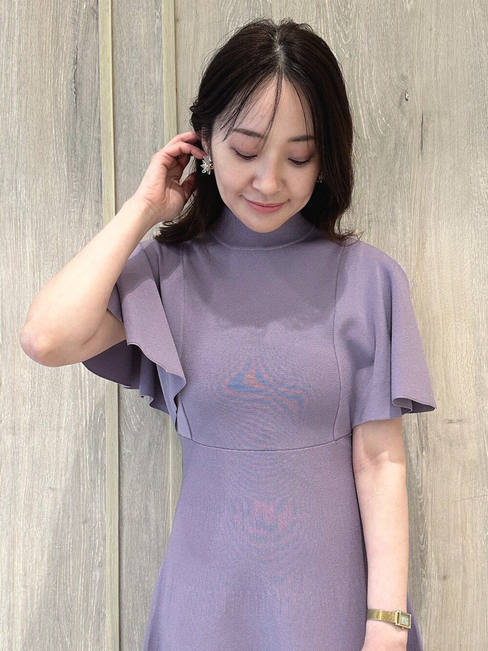 ブラウン系のハンドバッグ、ブラウン系のブーツ、パープル系のワンピースを着用したレディースの春コーディネートの5枚目の写真