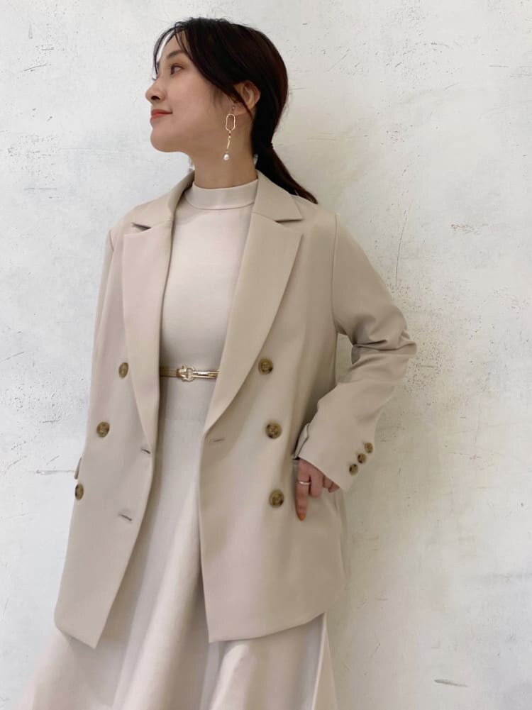 ベージュ系のブーツ、ベージュ系のテーラードジャケット、ホワイト系のワンピースを着用したレディースの秋コーディネートの5枚目の写真