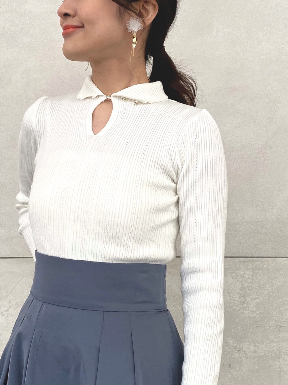 ブルー系のスカート、ホワイト系のニット/セーター、ホワイト系のキャミソールを着用したレディースの冬コーディネートの6枚目の写真