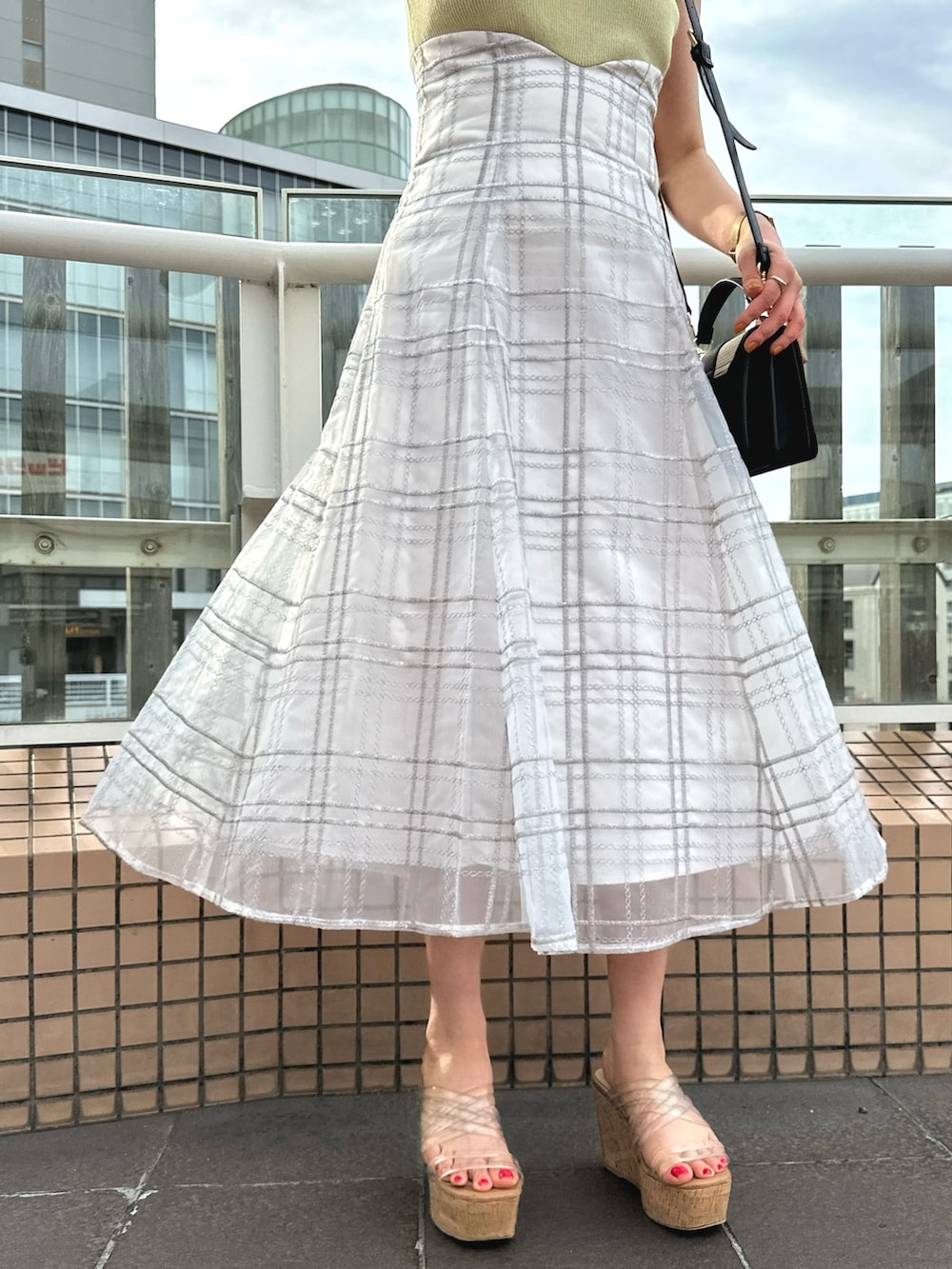 その他のサンダル、ブラック系のハンドバッグ、グリーン系のワンピースを着用したレディースの春コーディネートの7枚目の写真