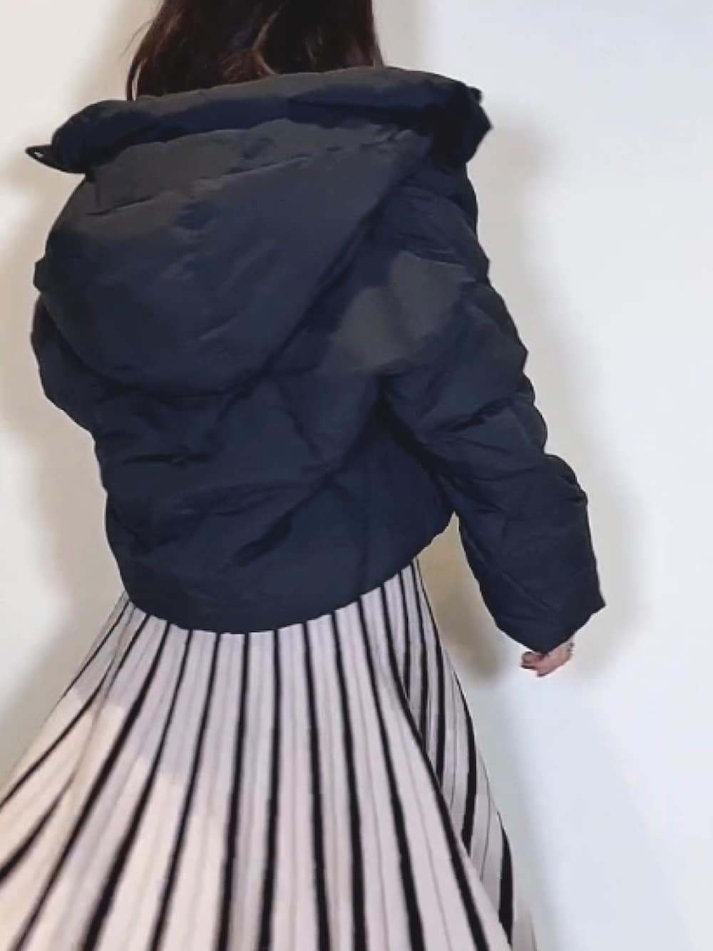 ブラック系のブーツ、ブラック系のワンピース、ブラック系のダウンジャケット/コートを着用したレディースの冬コーディネートの5枚目の写真