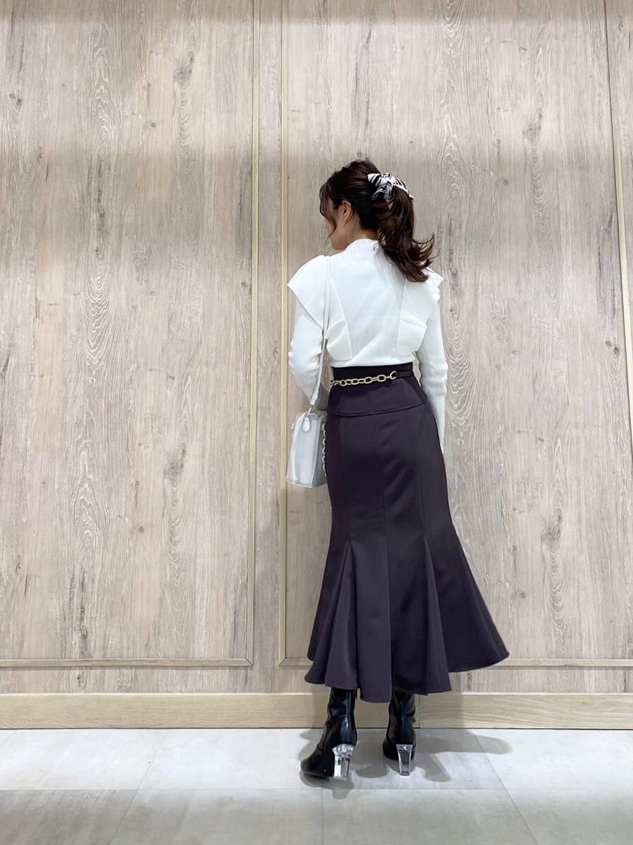 パープル系のスカート、ブラック系のその他シューズ、ホワイト系のニット/セーターを着用したレディースの冬コーディネートの3枚目の写真