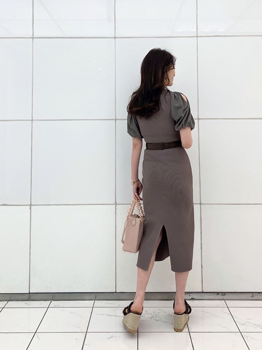 ピンク系のハンドバッグ、ブラウン系のワンピース、ブラウン系のサンダルを着用したレディースの春コーディネートの3枚目の写真