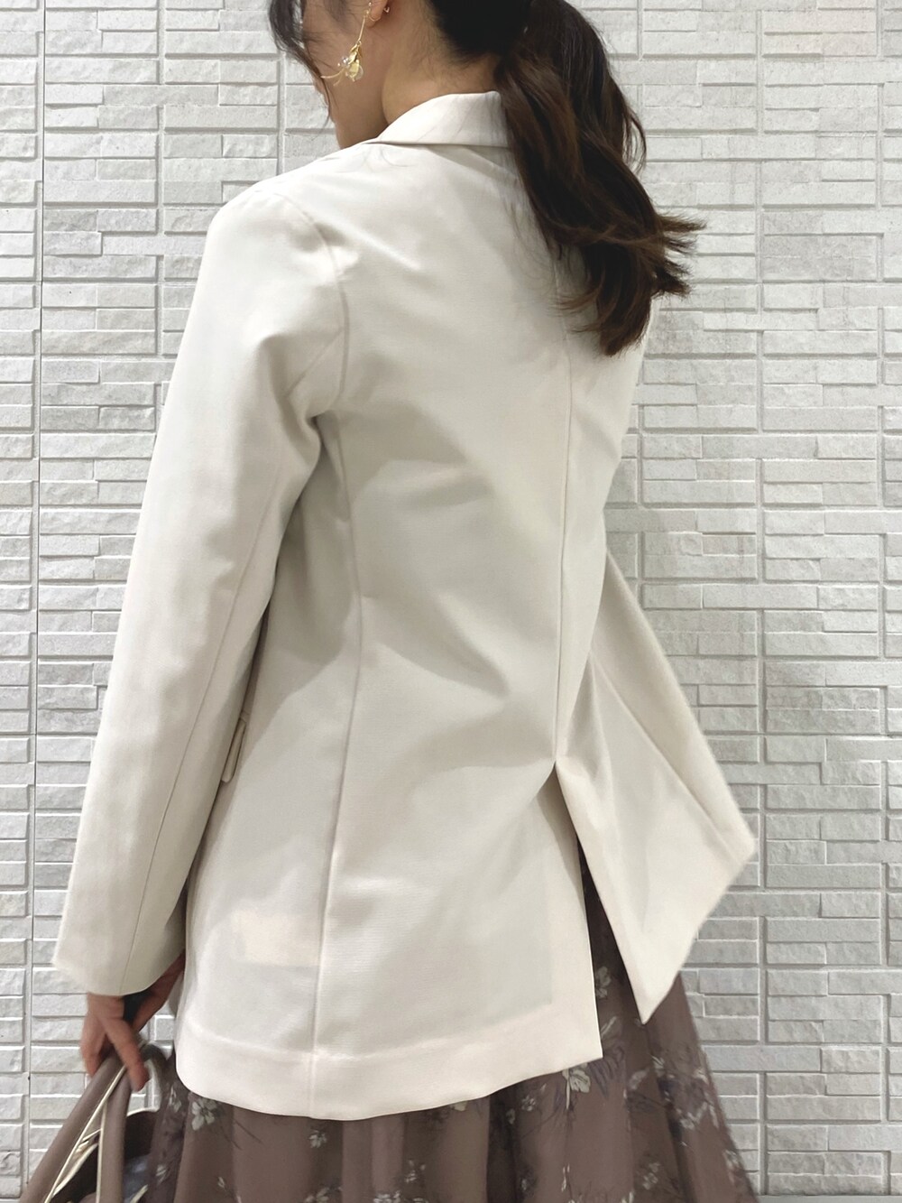 ベージュ系のブーツ、ホワイト系のテーラードジャケット、ベージュ系のハンドバッグを着用したレディースの冬コーディネートの6枚目の写真