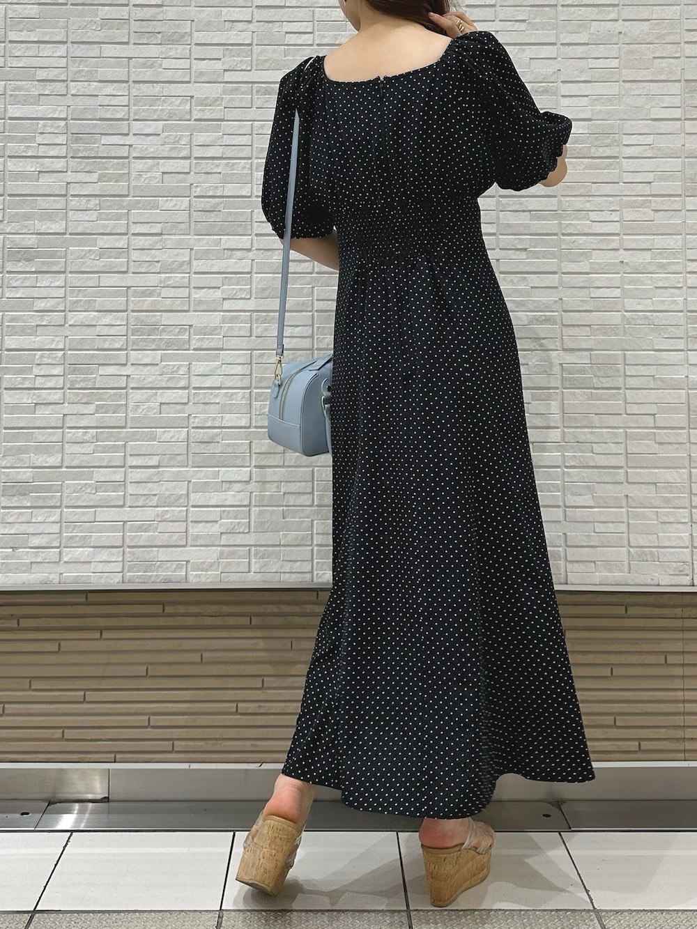 その他のサンダル、ブラック系のワンピース、ブルー系のボストンバッグを着用したレディースの夏コーディネートの3枚目の写真