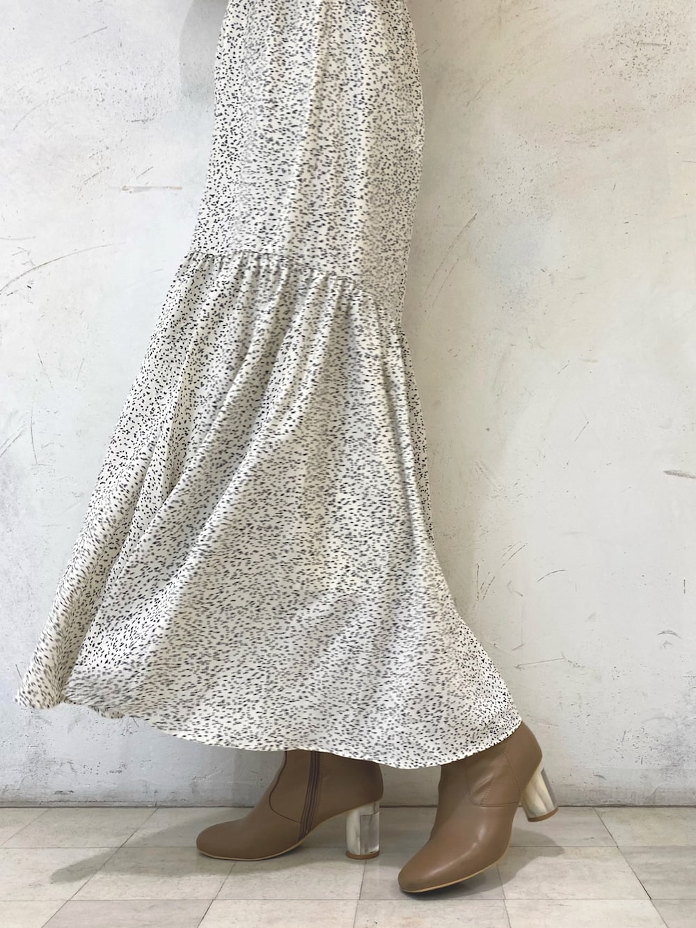 ホワイト系のワンピース、ベージュ系のブーツ、シルバー系のイヤリングを着用したレディースの秋コーディネートの8枚目の写真