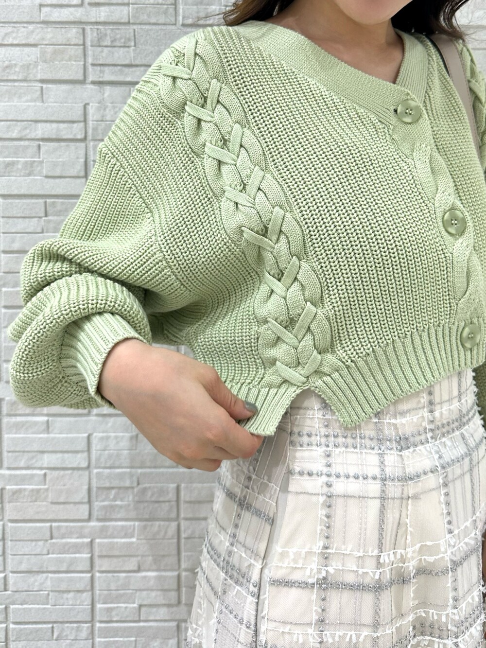 ホワイト系のハンドバッグ、グリーン系のカーディガン/ボレロ、ホワイト系のスカートを着用したレディースの秋コーディネートの6枚目の写真