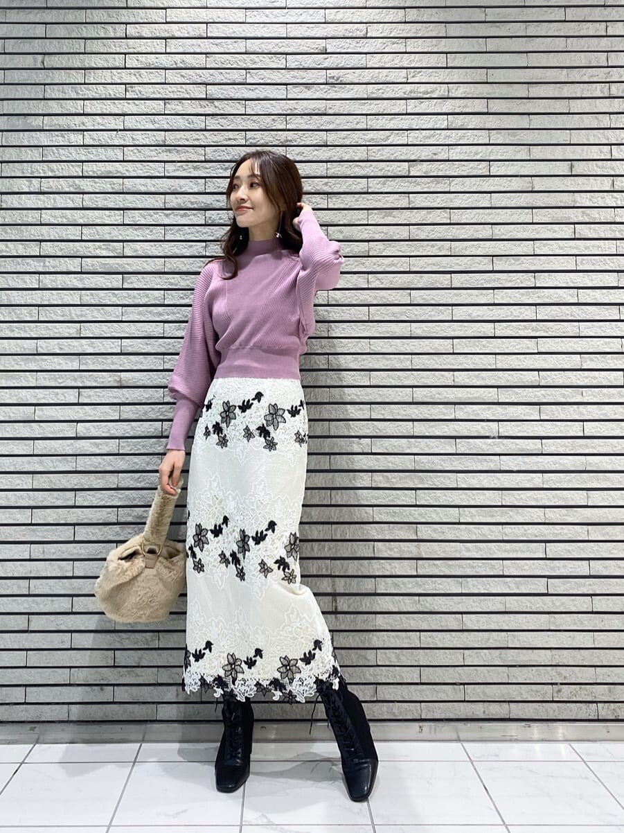 ホワイト系のスカート、ブラック系のブーツ、ピンク系のニット/セーターを着用したレディースの冬コーディネートの2枚目の写真