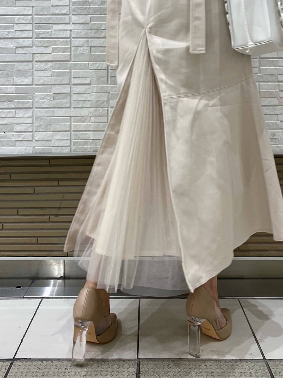 ベージュ系のパンプス、ホワイト系のワンピース、ピンク系のニット/セーターを着用したレディースの冬コーディネートの3枚目の写真