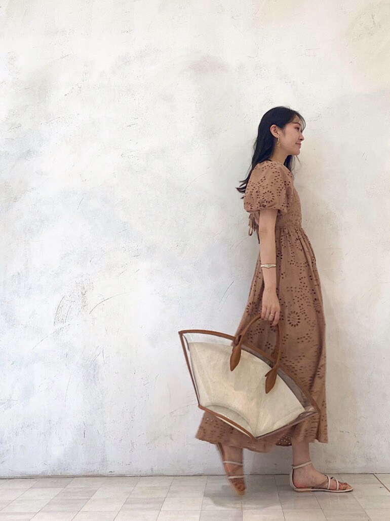 ブラウン系のトートバッグ、ベージュ系のワンピース、ベージュ系のサンダルを着用したレディースの春コーディネートの4枚目の写真