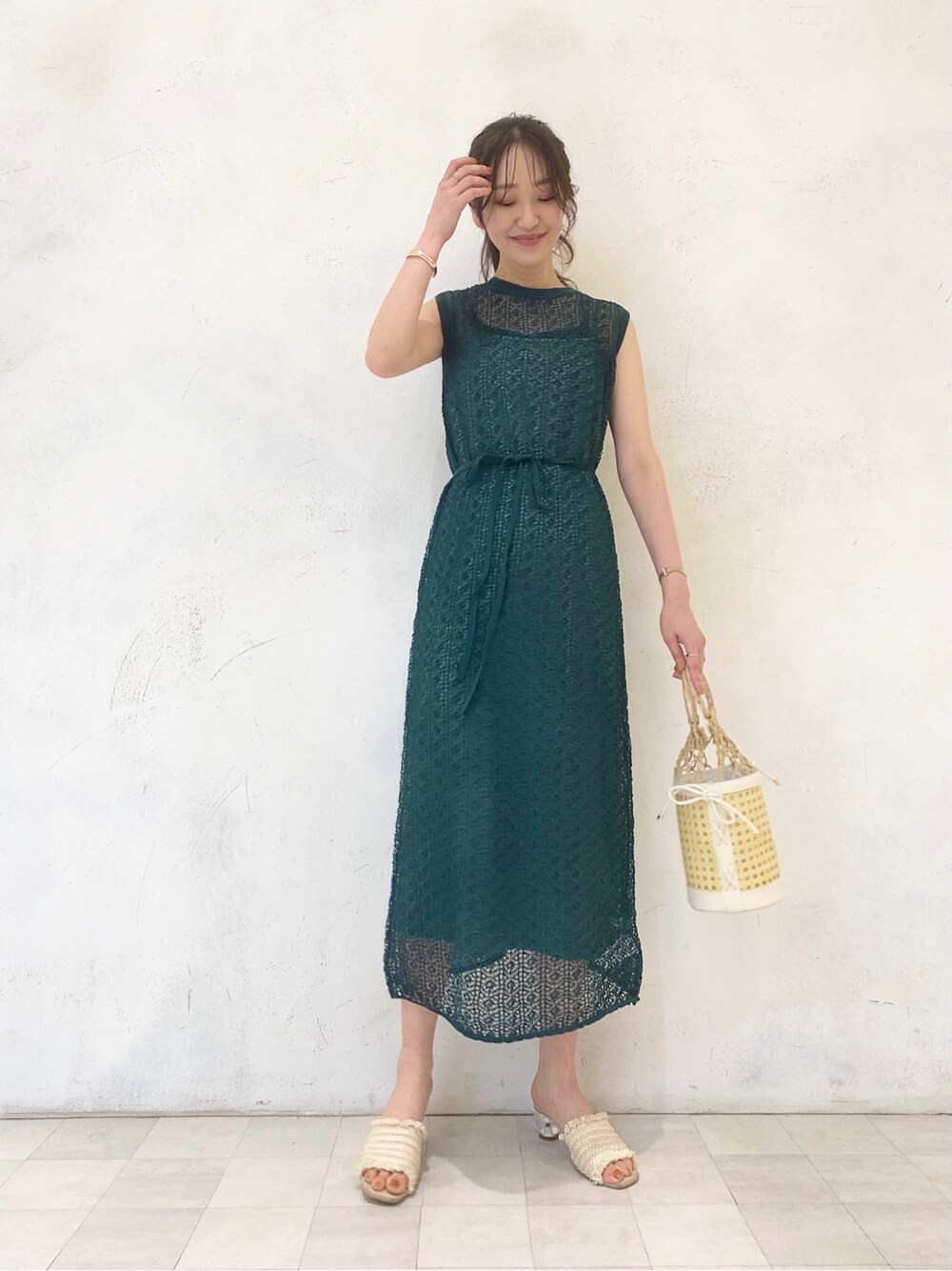 ホワイト系のサンダル、グリーン系のワンピース、ホワイト系のハンドバッグを着用したレディースの春コーディネートの7枚目の写真