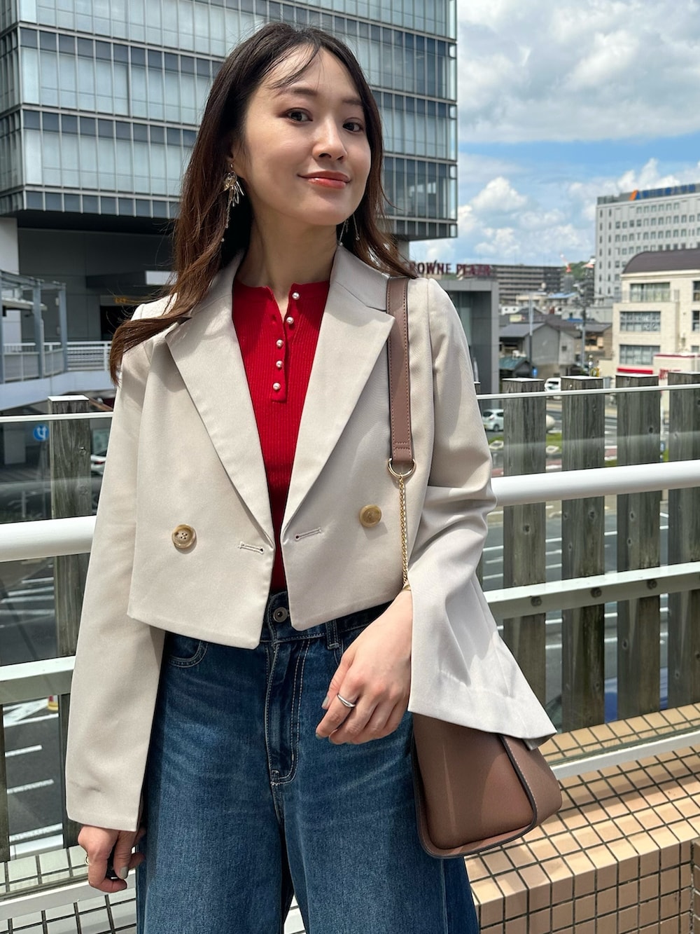 ブルー系のデニムパンツ、ブラウン系のブーツ、ブラウン系のハンドバッグを着用したレディースの夏コーディネートの5枚目の写真
