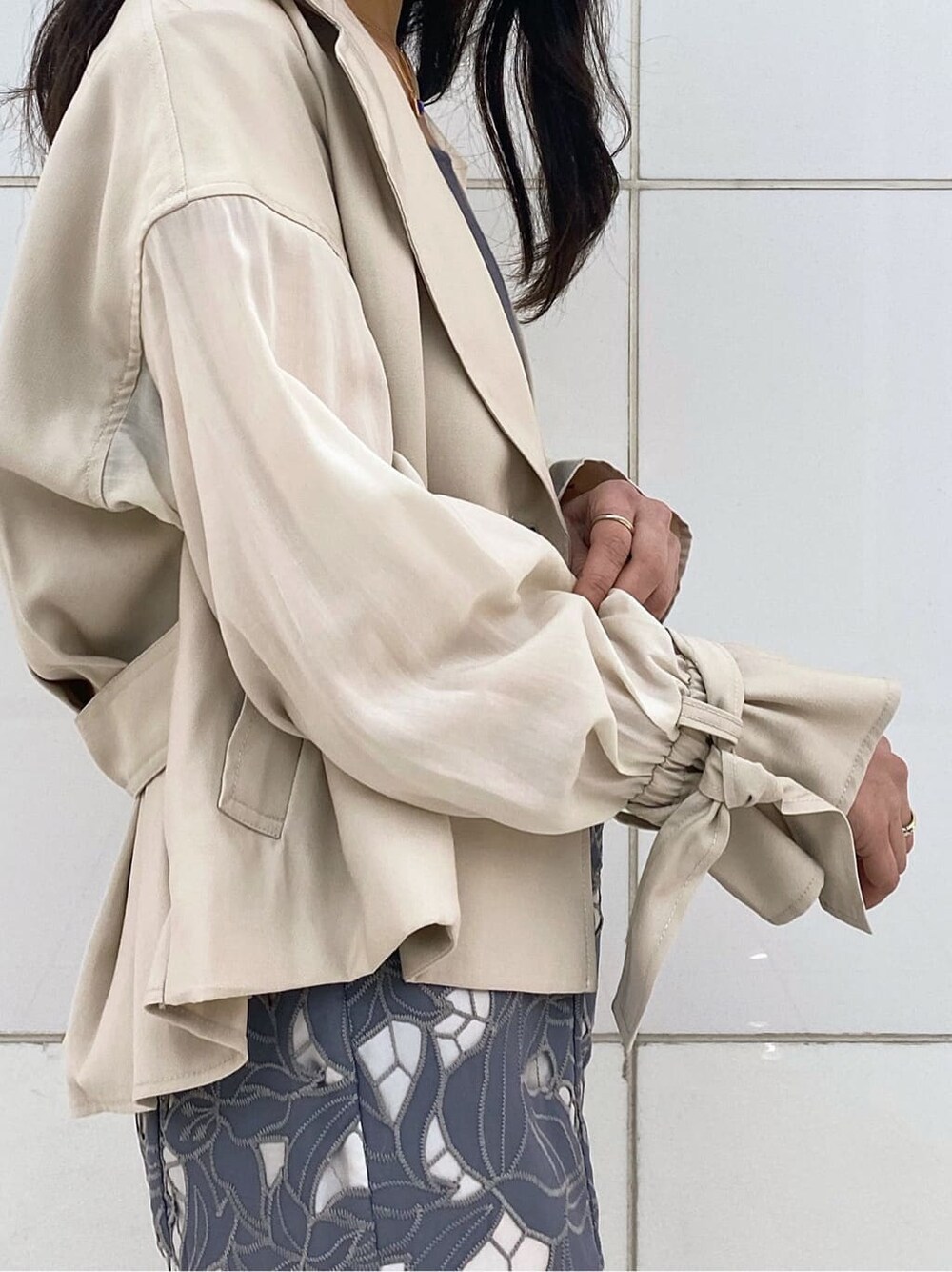 ホワイト系のTシャツ/カットソー、ベージュ系のトレンチコート、ホワイト系のパンプスを着用したレディースの春コーディネートの5枚目の写真