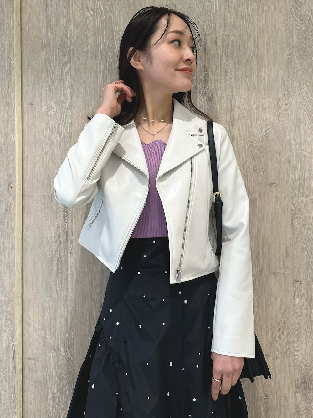 ピンク系のニット/セーター、ブラック系のハンドバッグ、その他のスカートを着用したレディースの春コーディネートの5枚目の写真