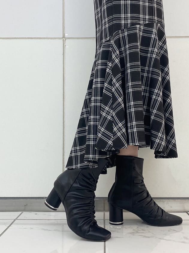 ブラック系のニット/セーター、ブラック系のその他シューズ、ブラック系のスカートを着用したレディースの秋コーディネートの8枚目の写真