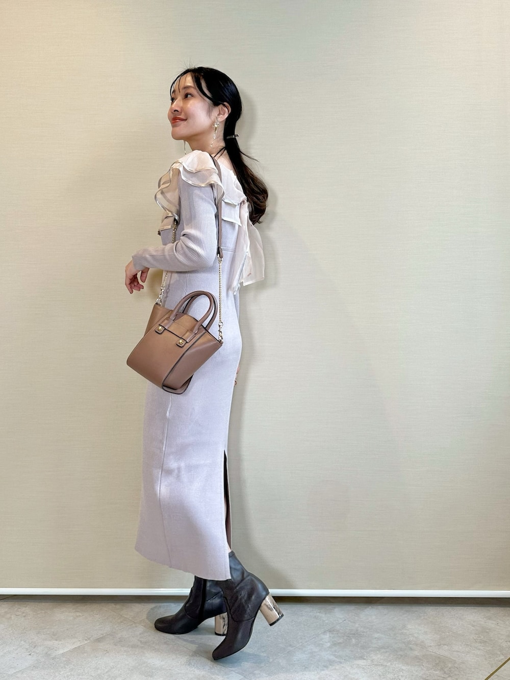 ブラウン系のブーツ、ブラウン系のハンドバッグ、ピンク系のワンピースを着用したレディースの冬コーディネートの3枚目の写真