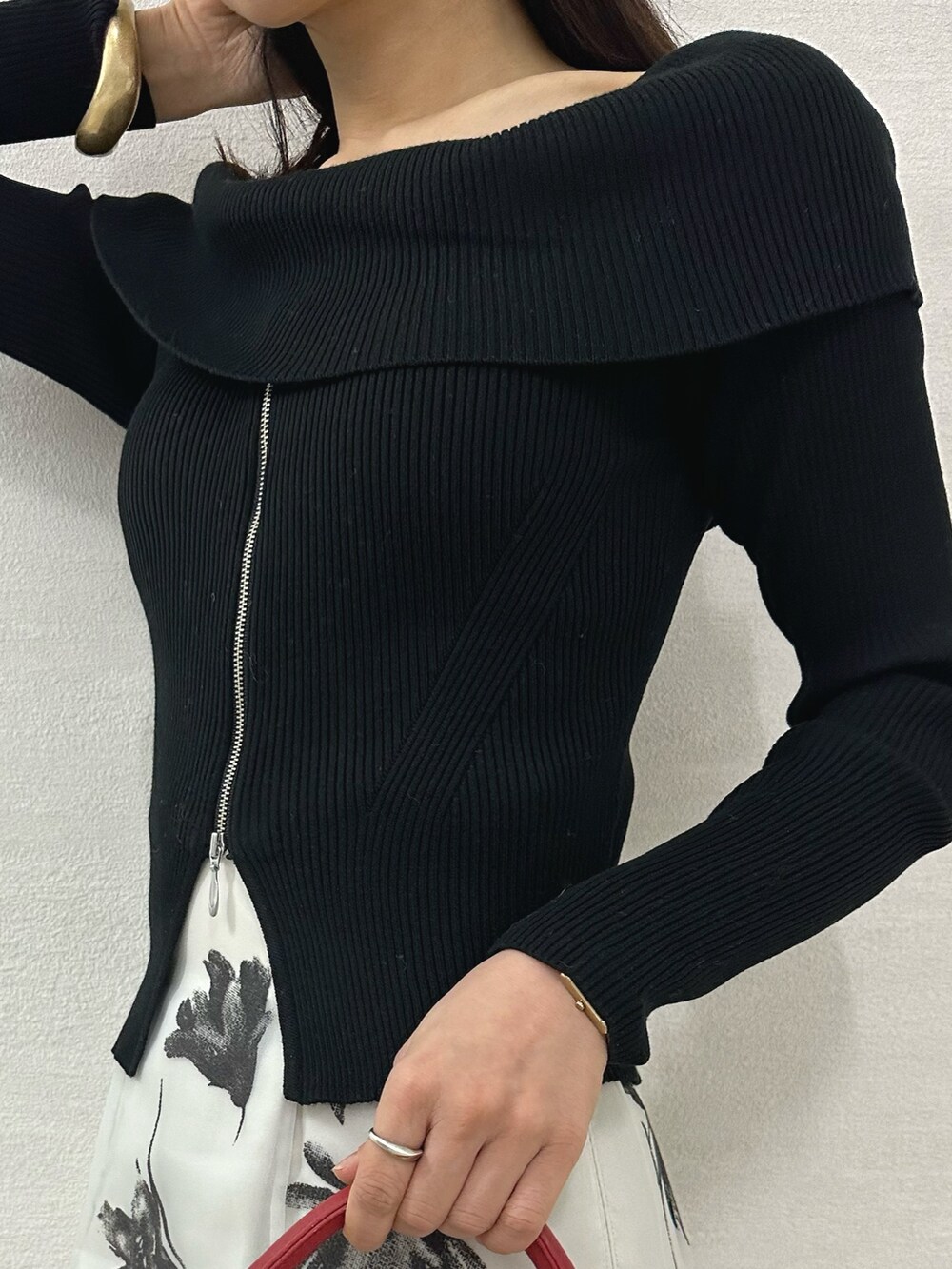 ブラック系のニット/セーター、ブラック系のブーツ、レッド系のハンドバッグを着用したレディースの秋コーディネートの6枚目の写真