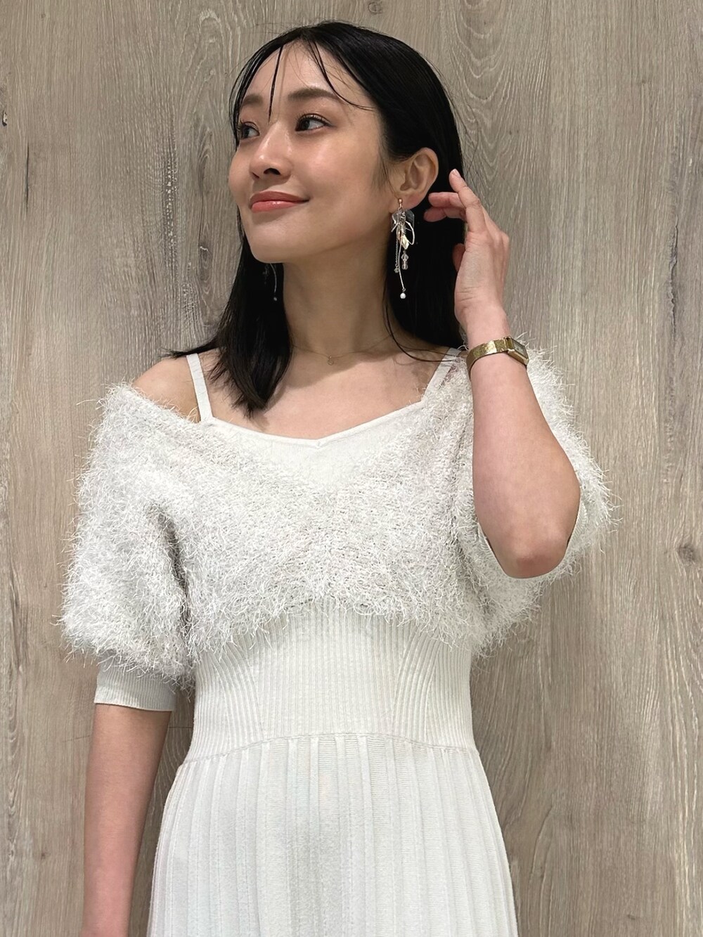 ホワイト系のブーツ、ホワイト系のワンピース、ゴールド系のイヤリングを着用したレディースの春コーディネートの5枚目の写真