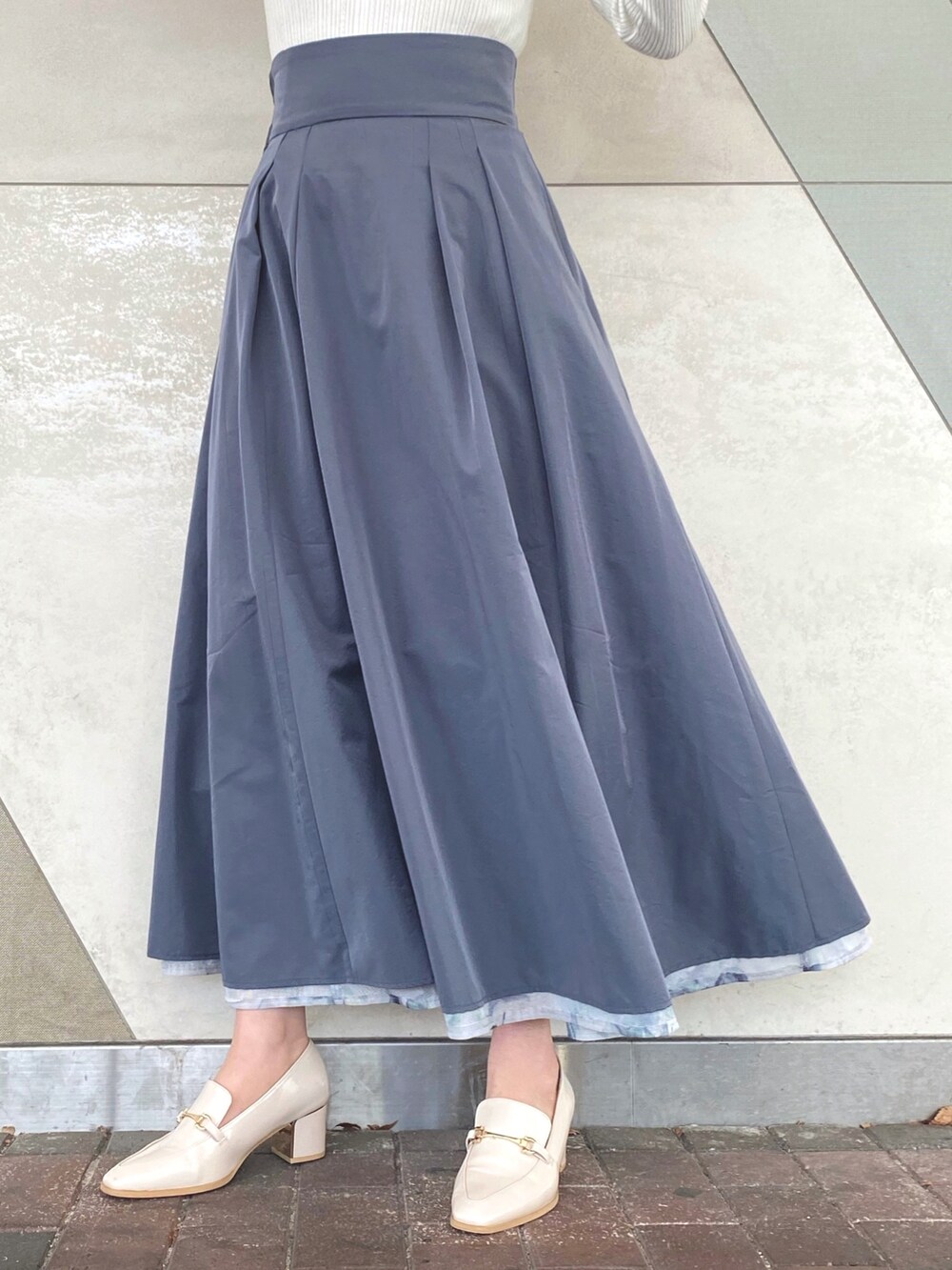 ブルー系のスカート、ホワイト系のニット/セーター、ホワイト系のキャミソールを着用したレディースの冬コーディネートの9枚目の写真