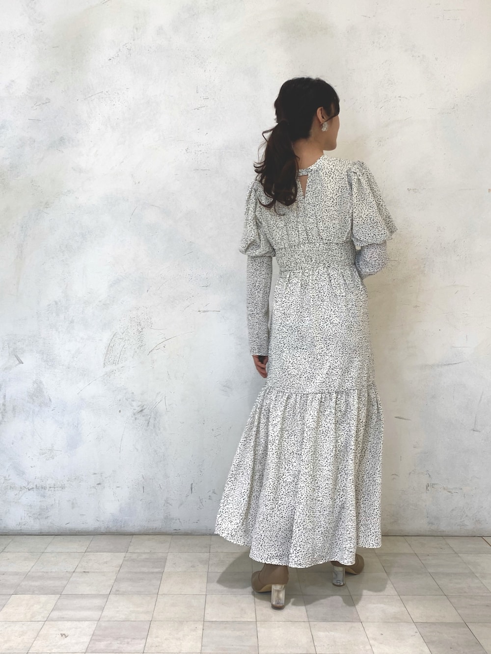 ホワイト系のワンピース、ベージュ系のブーツ、シルバー系のイヤリングを着用したレディースの秋コーディネートの4枚目の写真