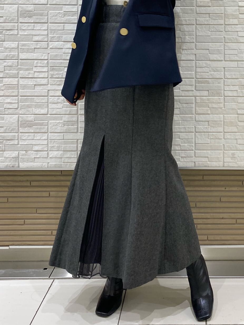 ブラック系のブーツ、ブルー系のテーラードジャケット、グレー系のスカートを着用したレディースの秋コーディネートの3枚目の写真