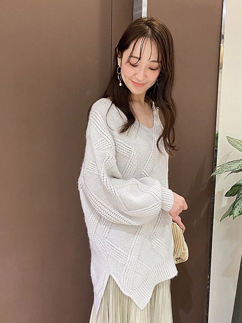 ベージュ系のクラッチバッグ、イエロー系のスカート、グレー系のニット/セーターを着用したレディースの秋コーディネートの6枚目の写真