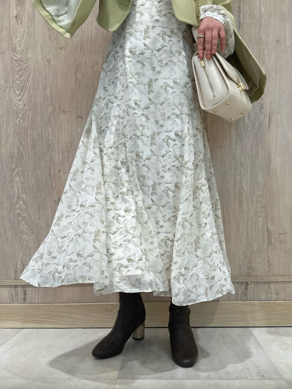 ホワイト系のハンドバッグ、ブラウン系のブーツ、グリーン系のテーラードジャケットを着用したレディースの冬コーディネートの9枚目の写真