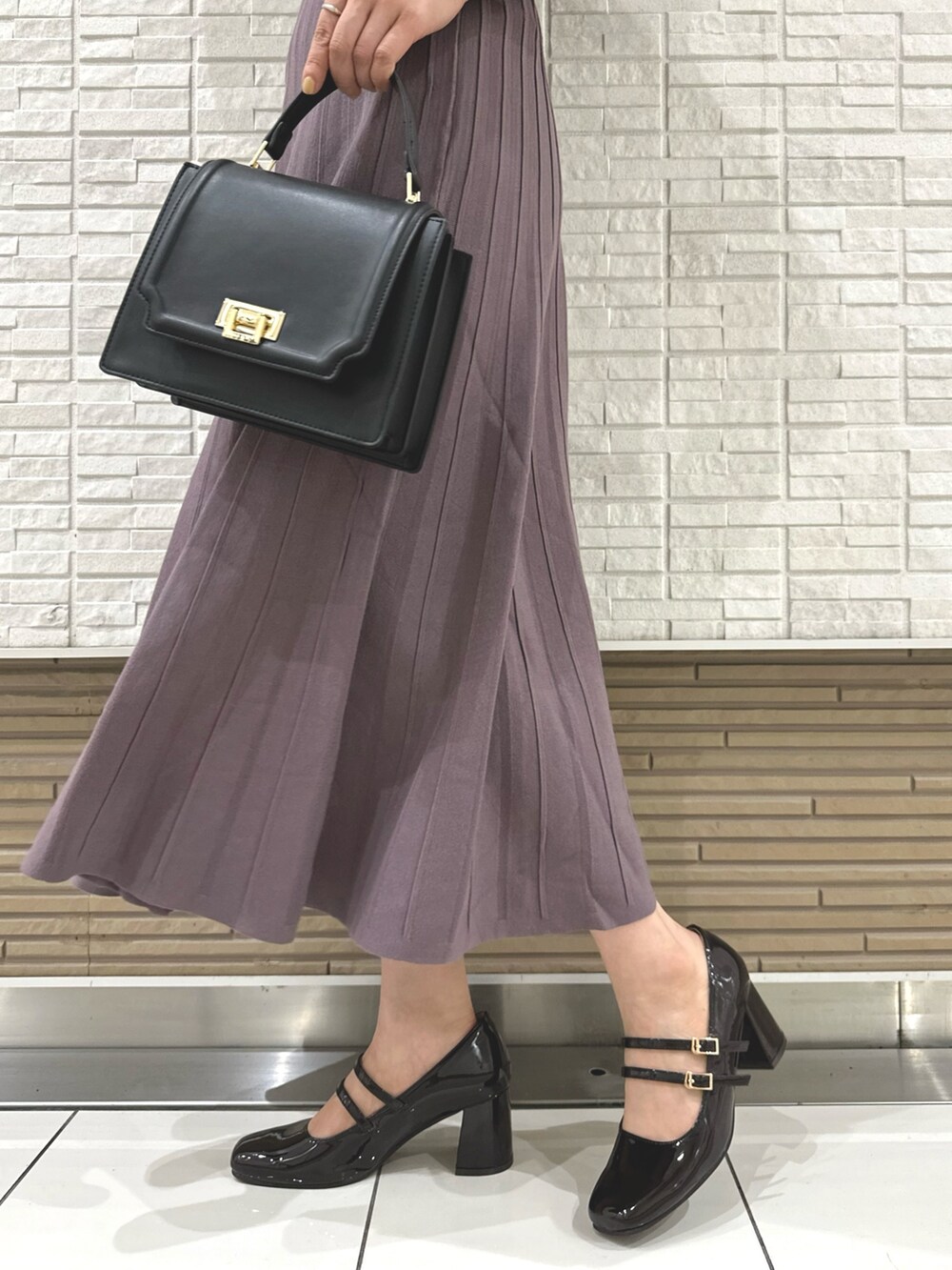 ブラウン系のパンプス、ブラック系のハンドバッグ、パープル系のワンピースを着用したレディースの夏コーディネートの8枚目の写真