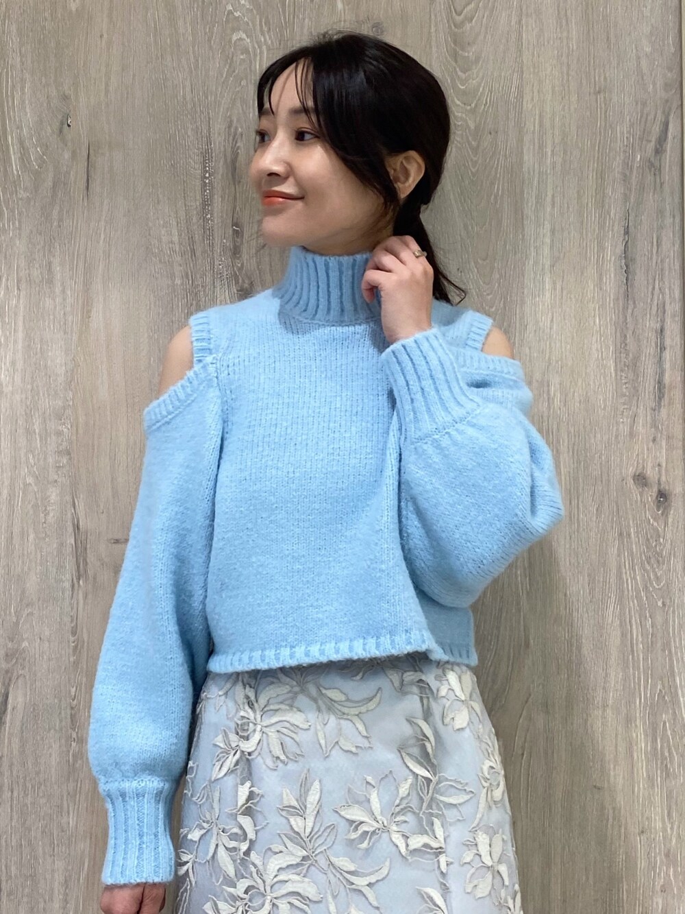 ブルー系のニット/セーター、ブルー系のスカート、ホワイト系のローファーを着用したレディースの秋コーディネートの4枚目の写真