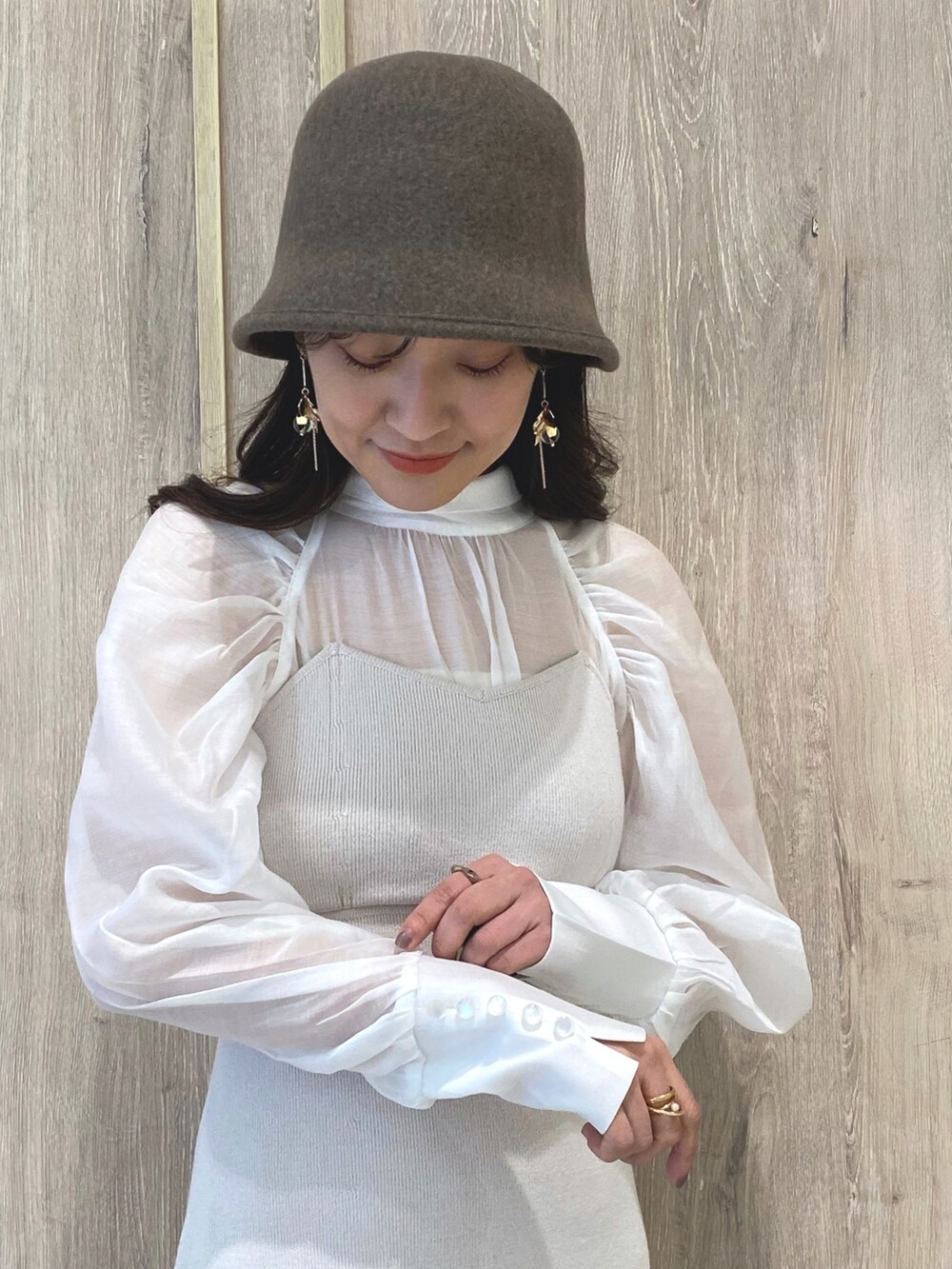 ベージュ系のブーツ、ホワイト系のワンピース、ホワイト系のチューブトップを着用したレディースの冬コーディネートの6枚目の写真