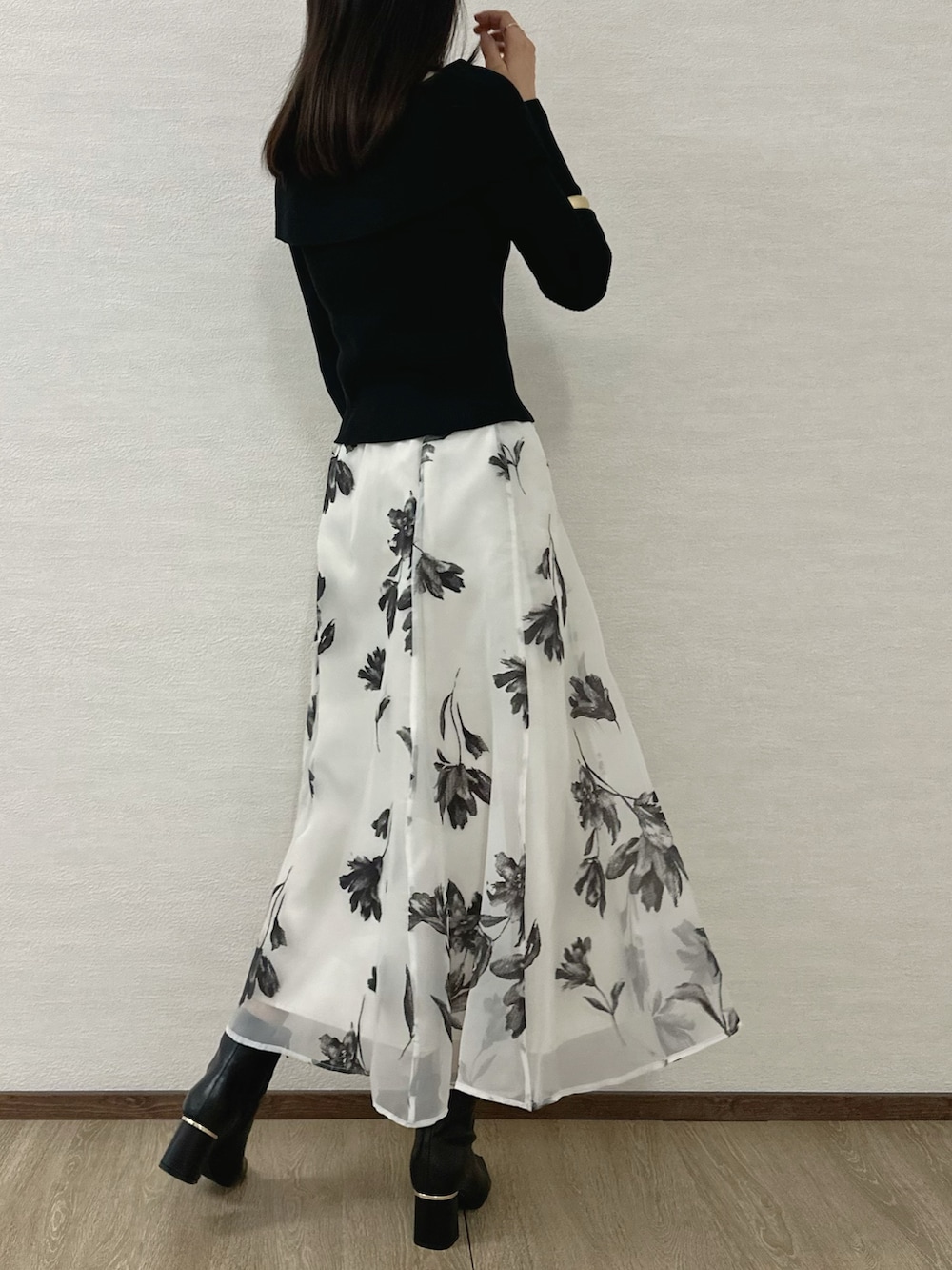 ブラック系のニット/セーター、ブラック系のブーツ、レッド系のハンドバッグを着用したレディースの秋コーディネートの4枚目の写真