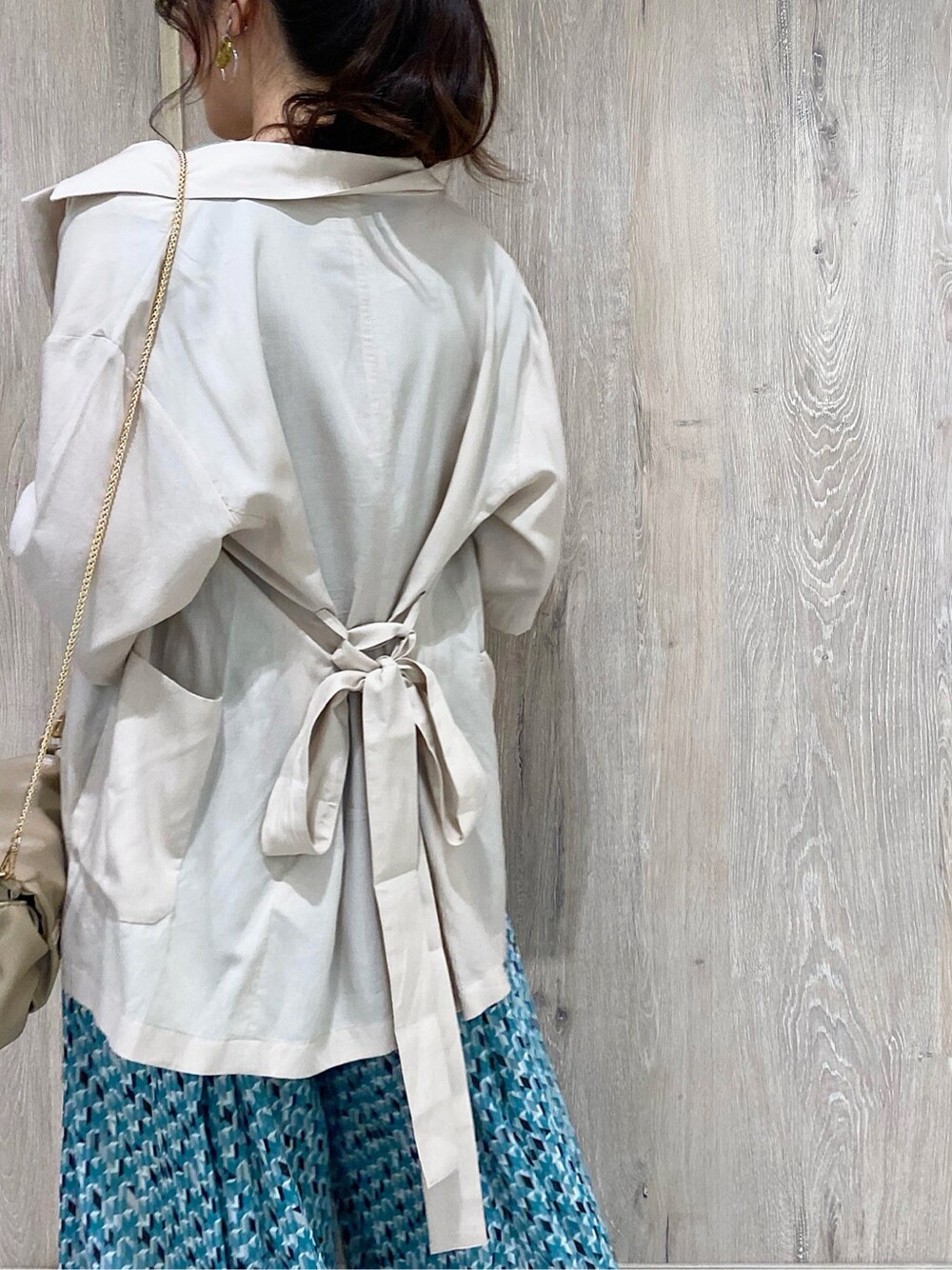 ホワイト系のキャミソール、ベージュ系のテーラードジャケット、ベージュ系のサンダルを着用したレディースの春コーディネートの6枚目の写真