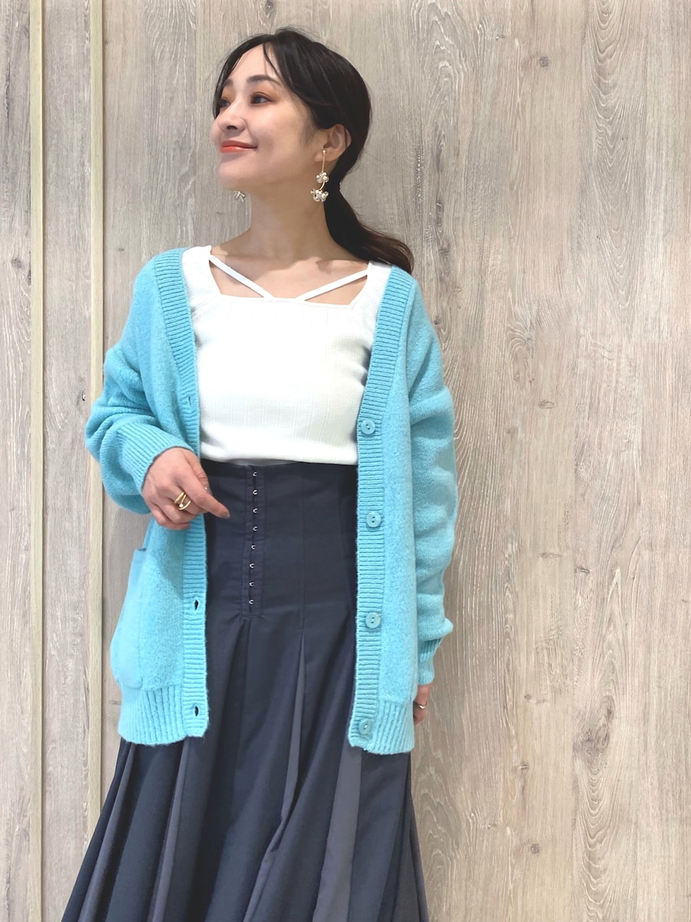 ホワイト系のローファー、グレー系のスカート、グリーン系のカーディガン/ボレロを着用したレディースの冬コーディネートの5枚目の写真