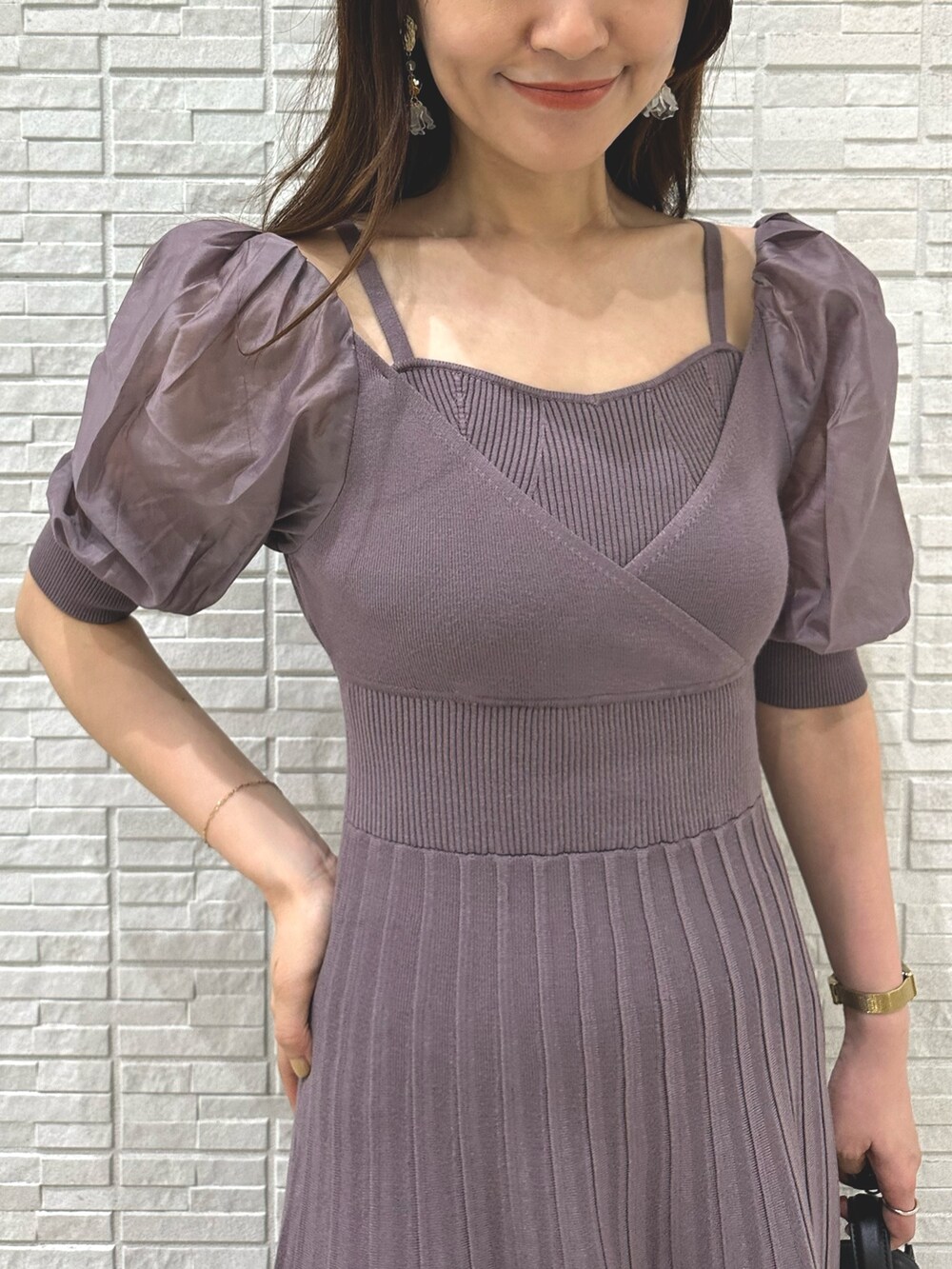 ブラウン系のパンプス、ブラック系のハンドバッグ、パープル系のワンピースを着用したレディースの夏コーディネートの5枚目の写真