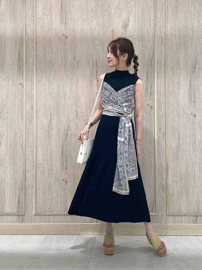 ブラック系のワンピース、イエロー系のサンダル、ホワイト系のハンドバッグを着用したレディースの夏コーディネートの3枚目の写真