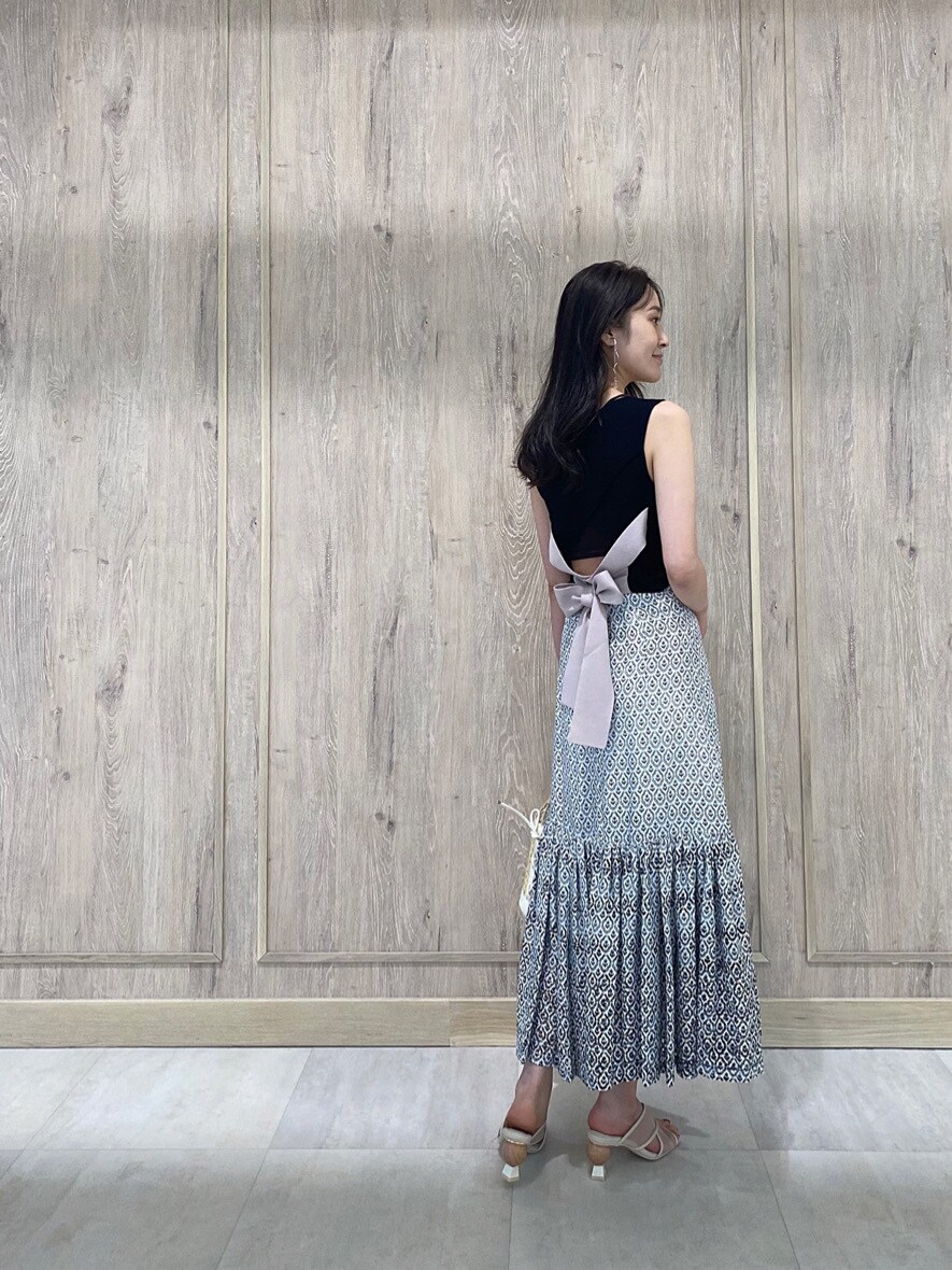 ホワイト系のハンドバッグ、ブルー系のスカート、ブラック系のニット/セーターを着用したレディースの夏コーディネートの3枚目の写真