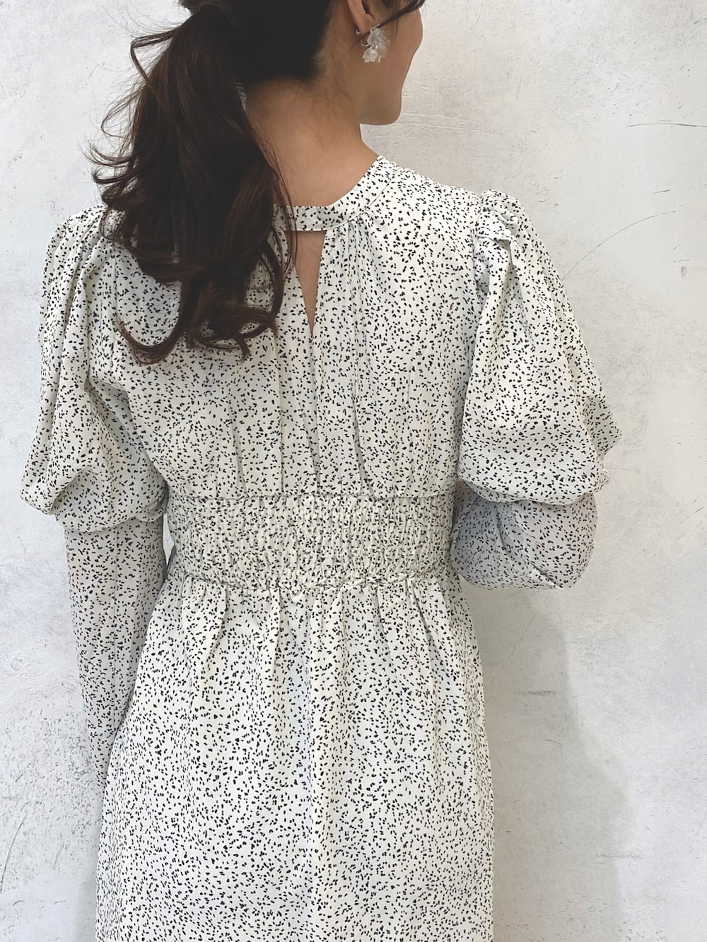 ホワイト系のワンピース、ベージュ系のブーツ、シルバー系のイヤリングを着用したレディースの秋コーディネートの7枚目の写真