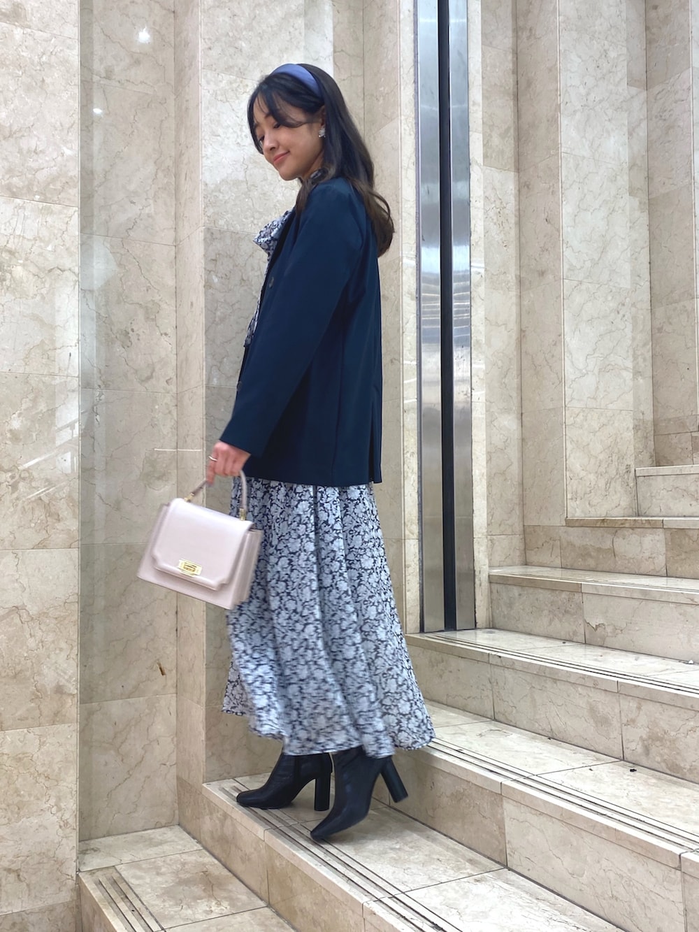 ブラック系のワンピース、ブラック系のブーツ、ブルー系のテーラードジャケットを着用したレディースの冬コーディネートの3枚目の写真