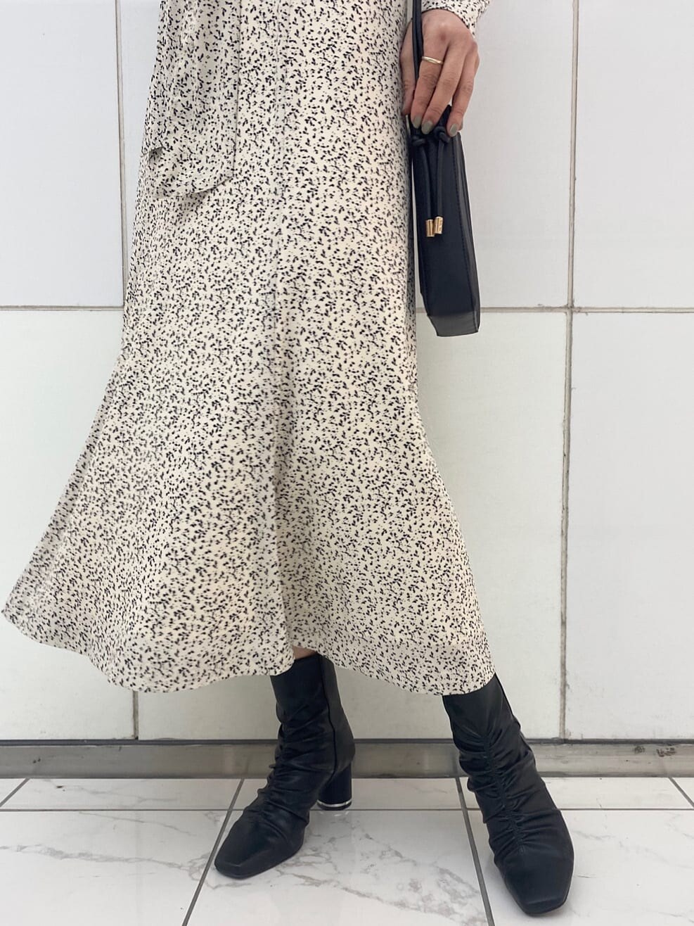 ブラック系のハンドバッグ、ブラック系のその他シューズ、ホワイト系のワンピースを着用したレディースの冬コーディネートの8枚目の写真