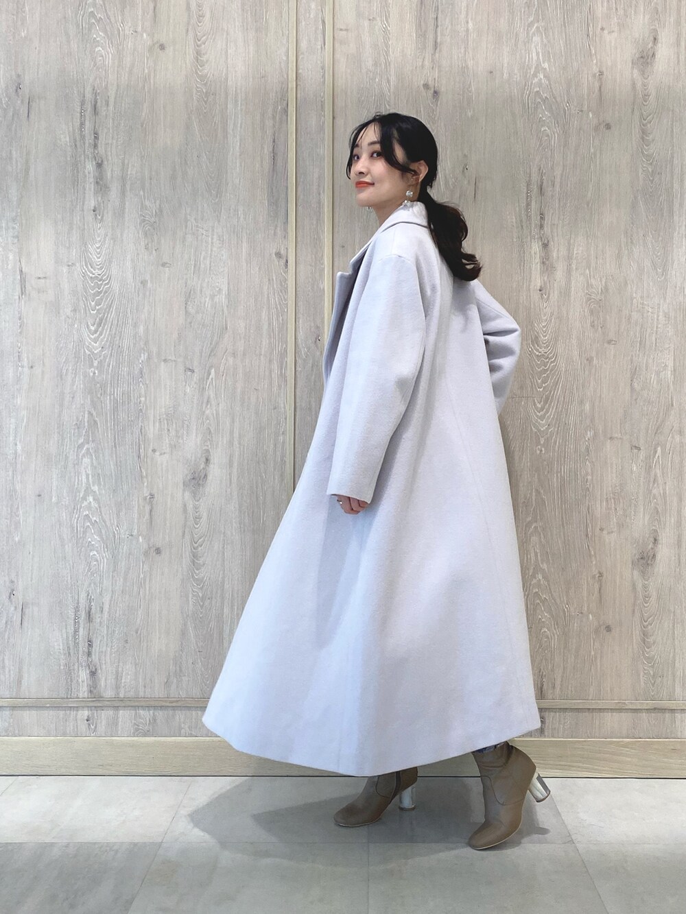 ベージュ系のブーツ、ピンク系のチェスターコート、ブラック系のワンピースを着用したレディースの冬コーディネートの4枚目の写真