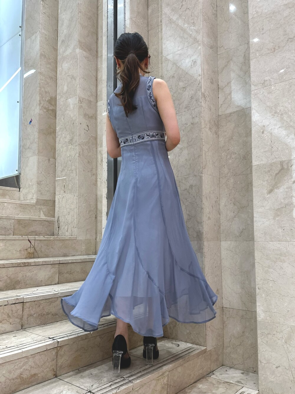 ブラック系のパンプス、ブルー系のドレス、シルバー系のイヤリングを着用したレディースの夏コーディネートの4枚目の写真