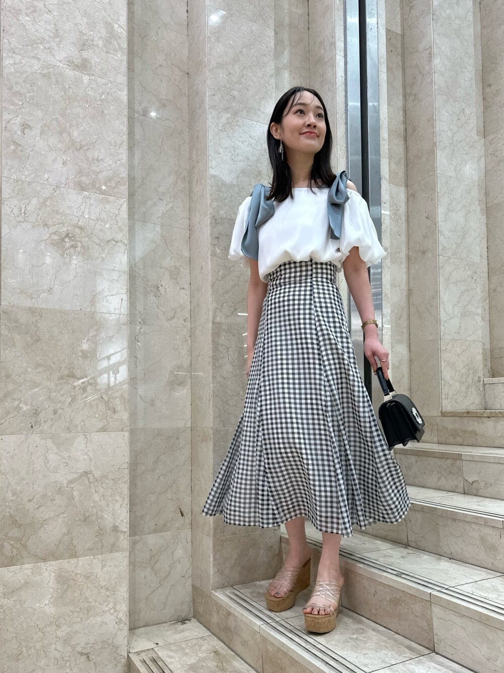 ホワイト系のシャツ/ブラウス、その他のスカート、ブラック系のショルダーバッグを着用したレディースの春コーディネートの2枚目の写真