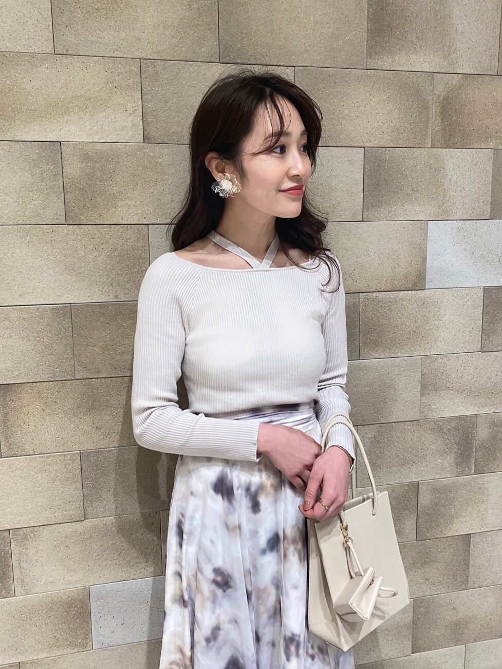 ベージュ系のトレンチコート、ベージュ系のトートバッグ、ホワイト系のニット/セーターを着用したレディースの冬コーディネートの4枚目の写真