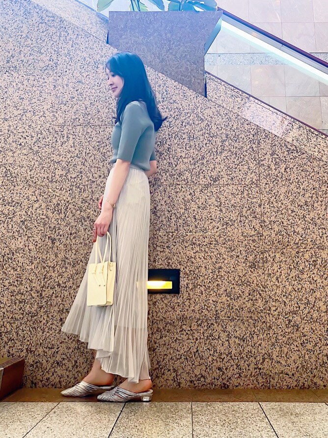 シルバー系のサンダル、シルバー系のスカート、ホワイト系のハンドバッグを着用したレディースの春コーディネートの2枚目の写真