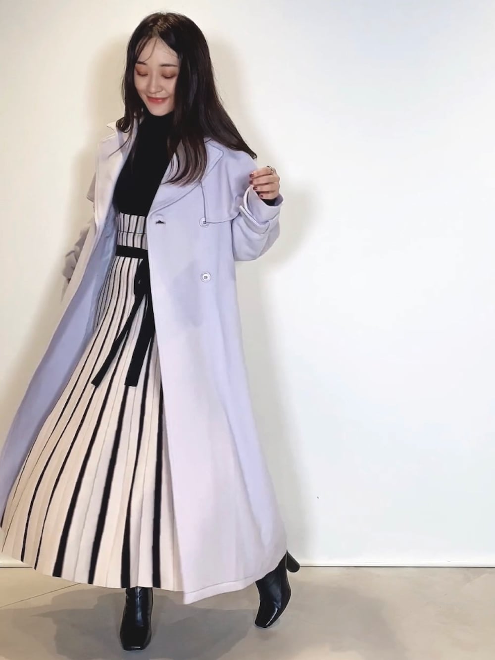 ブラック系のブーツ、ブラック系のワンピース、グレー系のその他アウターを着用したレディースの冬コーディネートの2枚目の写真