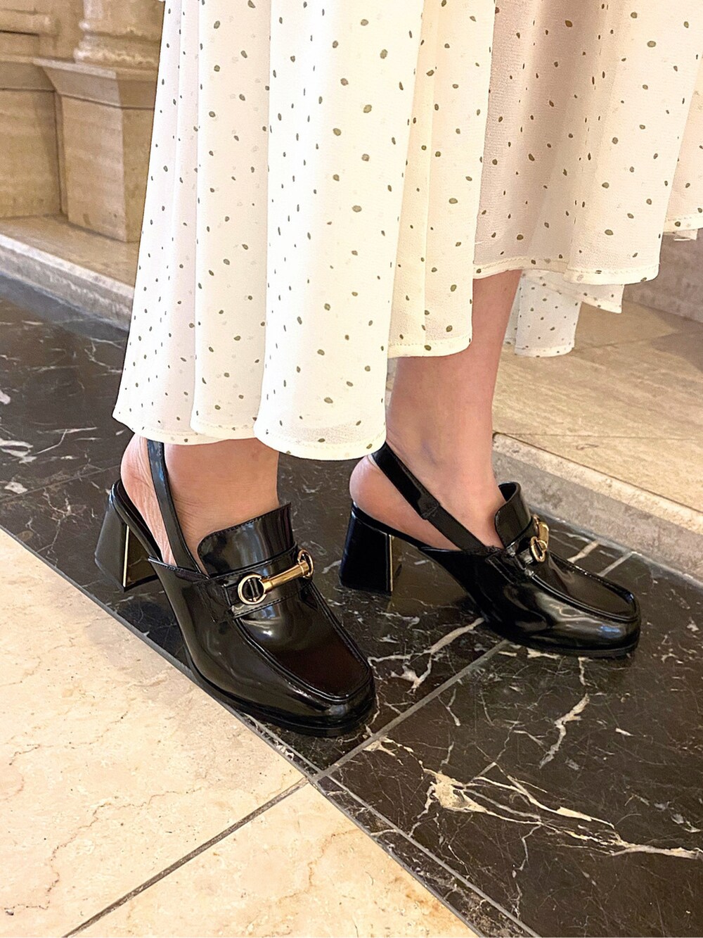 ホワイト系のスカート、ブラック系のローファー、ホワイト系のハンドバッグを着用したレディースの冬コーディネートの5枚目の写真